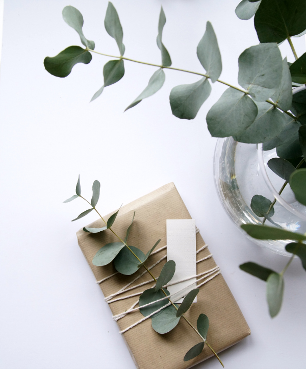 Christmas presents wrapped with brown Kraft paper and greenery- eucalyptus shown