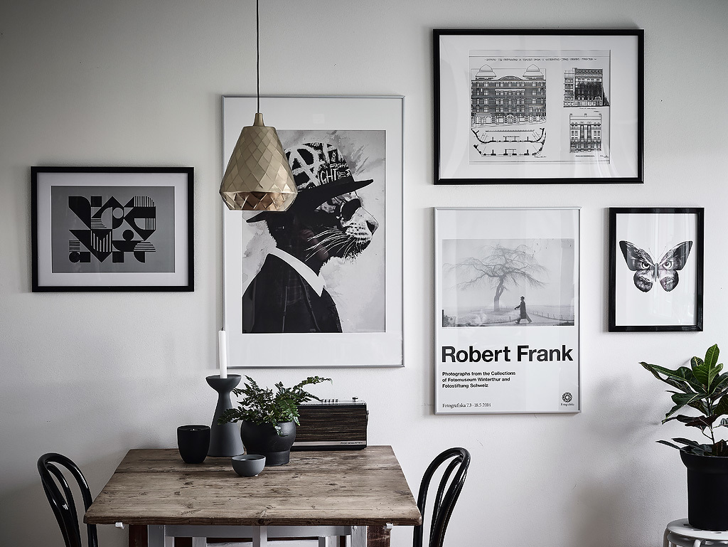 black and white picture wall and a brass pendant lamp