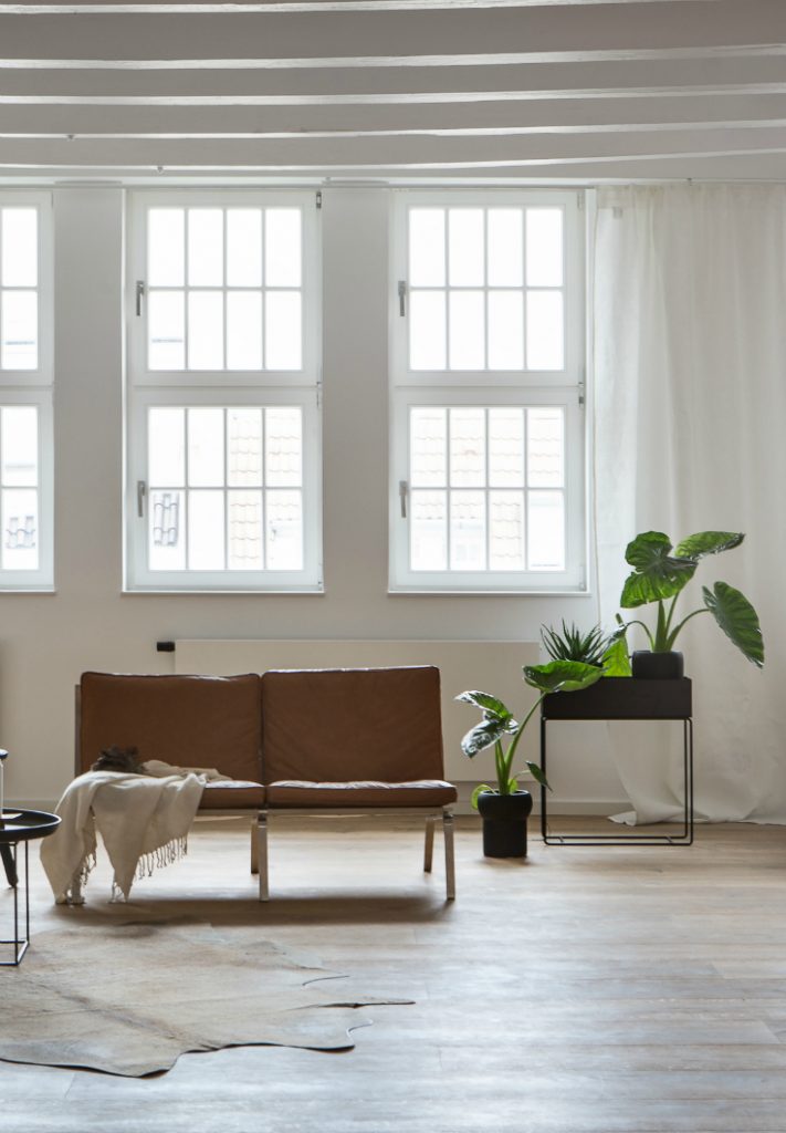 large open living room with the minimal Ferm Living plant box and green plants 