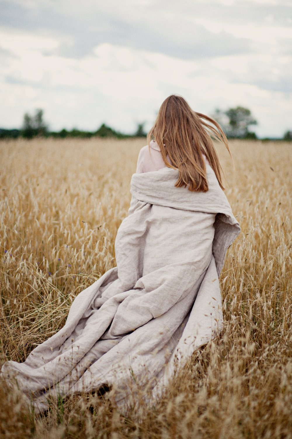 girl with duvet in field
