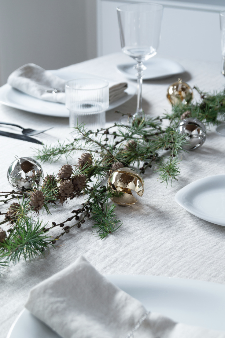 close up of natural Scandinavian inspired table setting. Natural foliage with gold and silver Christmas decorations