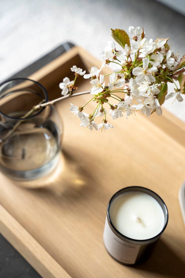 close up shot of a spring blossom branch styled on a Nordic inspired coffee table setting- a simple way to decorate your home with spring foliage 
