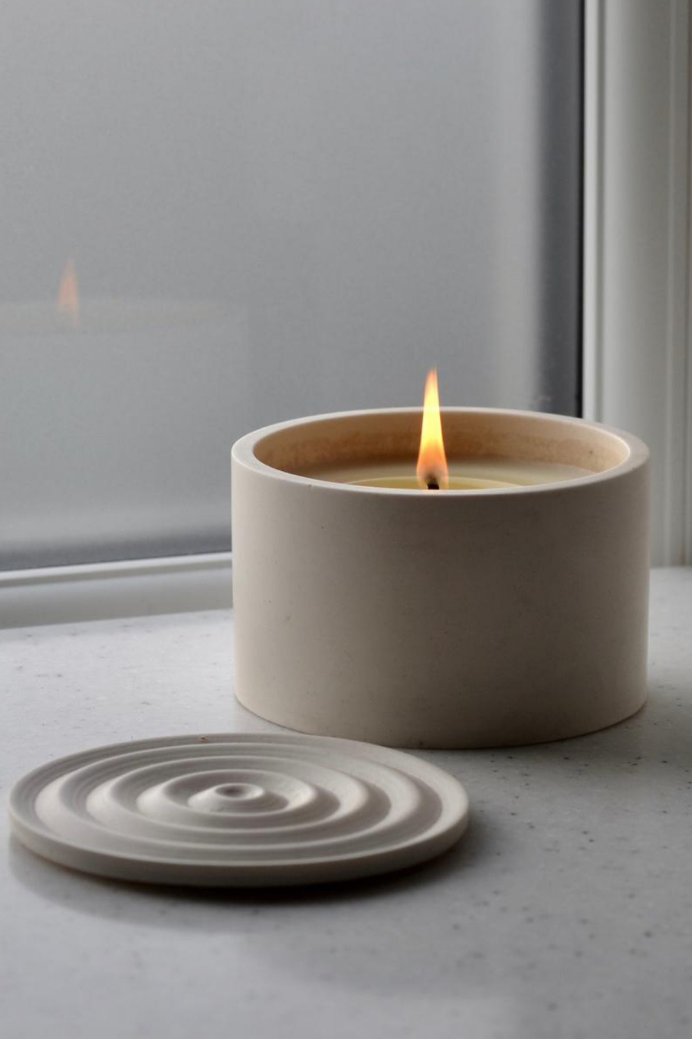 minimal soy wax candle in a beige Jesmonite container with lid